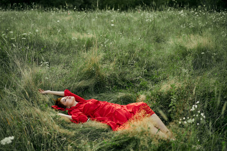 woman in a black dress lies in a field nature fashion summerの写真素材