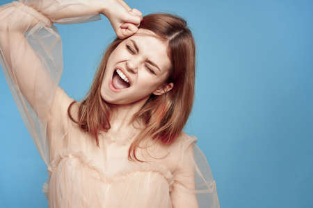 portrait of a woman hairstyle fun posing cosmetics fashion blue backgroundの写真素材