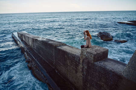 woman photographer in nature near ocean pierの写真素材