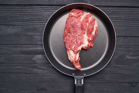 meat steak in a frying pan food ingredients kitchen wooden tableの写真素材