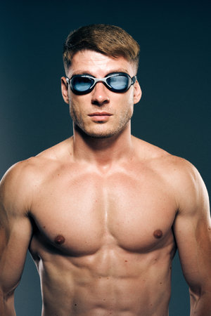 sports man with naked torso swimmer professional dark backgroundの写真素材
