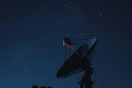 Satellite dish illuminated by the night sky full of stars, futuristic technology concept in the darknessの素材