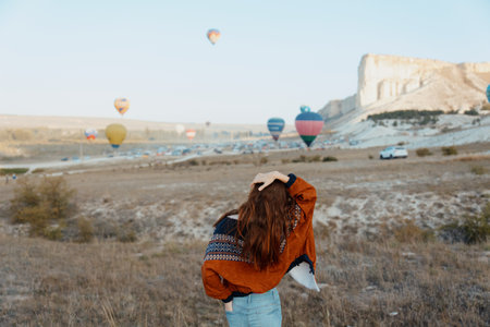 Spectacular view of woman gazing at colorful hot air balloons in cappadocia, turkeys iconic travel destinationの写真素材