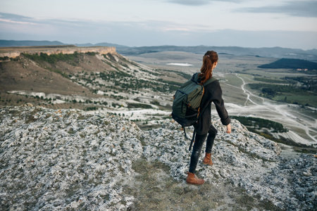 adventure awaits woman with backpack on mountain peak overlooking valley and majestic mountains