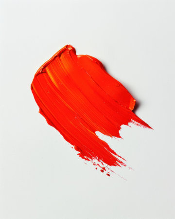 Bright orange paint stroke on a clean white background, showcasing a dynamic and abstract artistic textureの素材