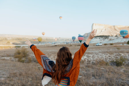 woman celebrating at colorful hot air balloon festival in cappadocia, turkeyの写真素材