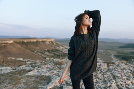 Woman standing triumphantly atop mountain peak gazing into the distanceの写真素材