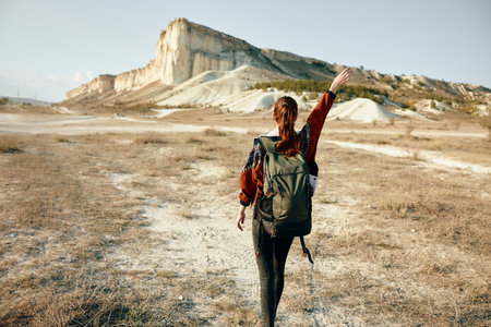 Enthusiastic hiker embracing the stunning mountain landscape during a peaceful moment in natureの写真素材