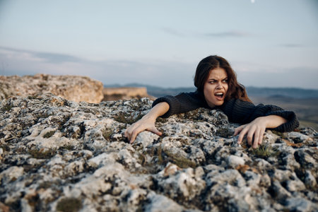 Captivated by the sky woman lying on a rock, mouth agape, eyes wide open in awe of the viewの写真素材