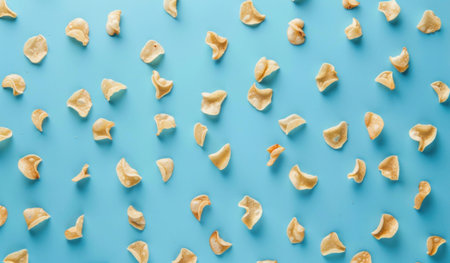 A flat lay of scattered crunchy snacks on a bright blue background, creating a fun and vibrant compositionの素材