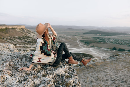 serene woman contemplating majestic mountain landscape from high summitの写真素材