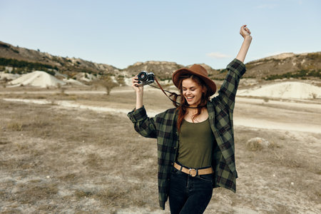Female photographer capturing the beauty of the desert landscape with a camera in handの写真素材