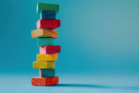 Colorful wooden blocks stacked on top of each other, creating a fun and vibrant design against a bright turquoise background. Playful and creative concept.の素材
