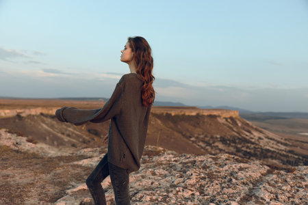 Empowered woman embraces the world from mountain peakの写真素材