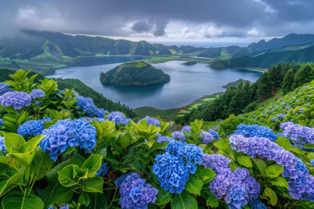 Scenic view of blue hydrangeas blooming near a tranquil lake surrounded by lush green hills under a cloudy sky. Nature and landscape concept.の素材