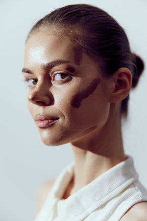 Portrait of a confident female model showcasing unique skin texture and natural beauty in a minimalist setting, emphasizing diversity and individuality.の写真素材