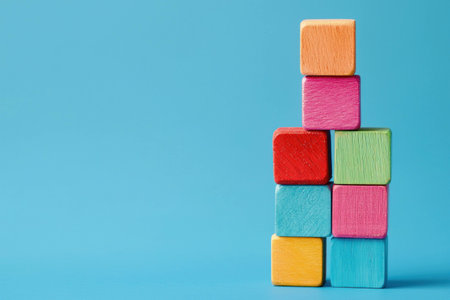 Colorful wooden blocks stacked in a playful arrangement on a bright blue background, ideal for children s education and development themesの素材