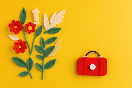 Vibrant yellow background with red flowers and a stylish red bag, perfect for spring fashion concepts and seasonal decorの素材