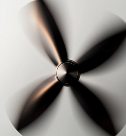 Minimalist ceiling fan with sleek black blades spinning, creating a dynamic motion against a simple white background, perfect for modern home decor and interior designの素材