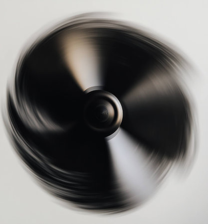 A dynamic and abstract representation of motion, featuring a spinning black object on a light background, capturing the essence of energy and speed in a modern designの素材