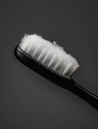 Close up of a black toothbrush with foam, highlighting dental hygiene, perfect for promoting oral care and healthy habits in lifestyle imageryの素材