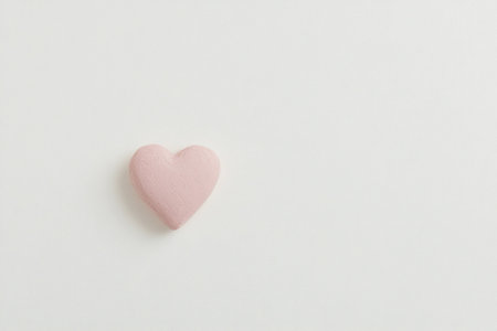 A soft pink heart on a minimalistic white background, symbolizing love and affection, perfect for romantic themes or emotional conceptsの素材