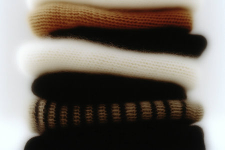 Cozy knit sweaters stacked in a warm fall palette, showcasing versatile textures and seasonal styles for autumn fashionの素材