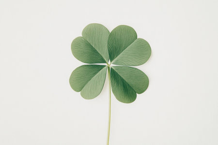 A close up of a four leaf clover on a pale background, symbolizing good luck and positivity, ideal for nature and wellness themesの素材