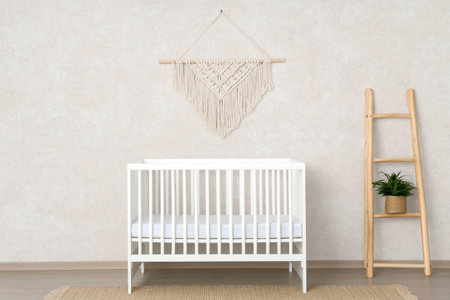 Minimalistic nursery interior with a white crib, macrame wall decor, and wooden ladder, creating a serene and cozy atmosphere for a baby roomの素材