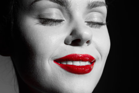 Black and white portrait of a woman with red lips, showcasing beauty and elegance in a striking contrast, perfect for beauty and fashion themes.の写真素材