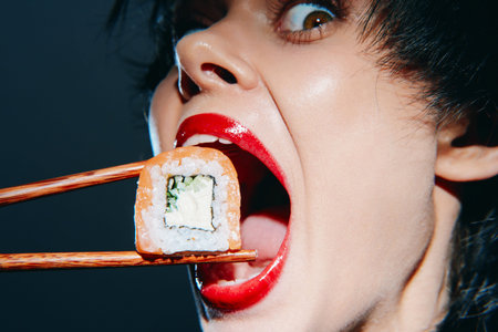 Bold woman with red lips excitedly eating sushi with chopsticks, showcasing vibrant colors and...