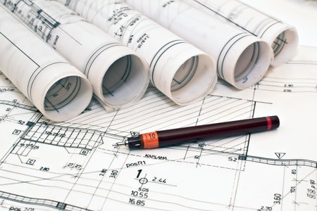 heap of design and project drawings on table background