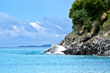Waves crashing over rock formation cliffs of corfu greeceの写真素材