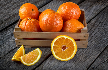 fresh and ripe orange fruits on a wooden tableの写真素材