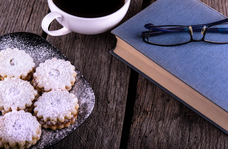 vintage book cup of coffee and gingerbread cookies on grungy wooden backgroundの写真素材