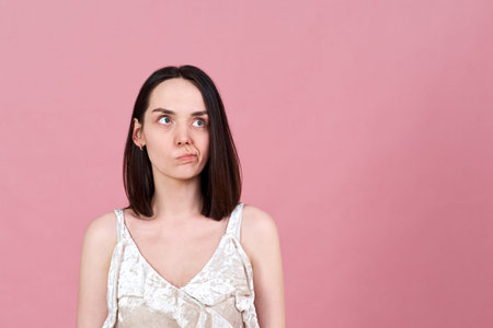 horizontal Studio portrait of a beautiful brunette girl with a thoughtful preoccupied look. She...