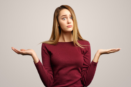 Photo of surprised  European woman has long hair, keeps breath bated, keeps hands with fear, stares with bugged eyes. Isolated on white background in Studio.の写真素材