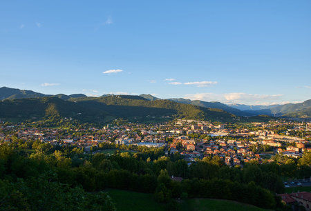 Panorama view on Bergamo city with Alps mountains and blue cloudy sky in far background. Roofs of...