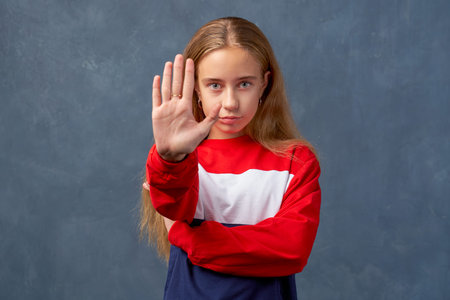 woman feels danger, holds palm in stop sign