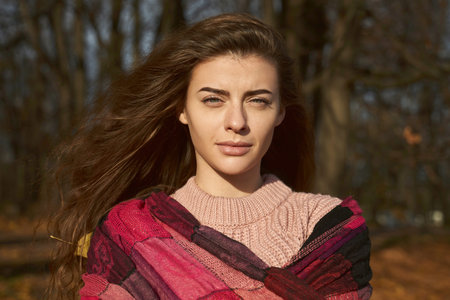 Portrait of young feminine lady frowns from sun