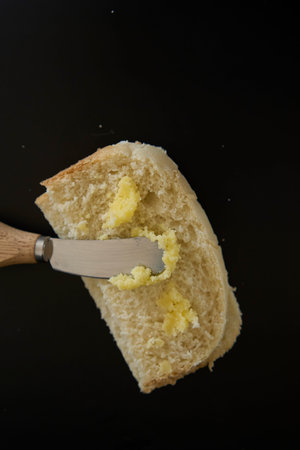 butter ghee in a transparent jar with homemade bread on  black background