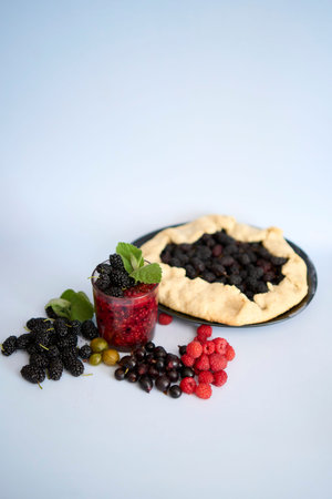 galette pie with mulberry and  multivitamin smoothie with a mulberry, raspberry, gooseberry, currant, mint, orange, gooseberryの写真素材