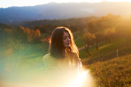 portrait young woman in mustard sweater in autumn mountains at sunset