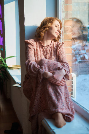 dreamy middle-aged woman by the window