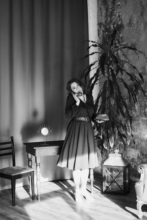 middle-aged woman in retro clothes with a retro phoneの写真素材