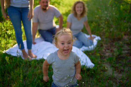 toddler screams and cries in front of family on picnic in gardenの写真素材