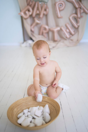 a photo session on the first birthday of a baby girl, baby play with decorative rocks