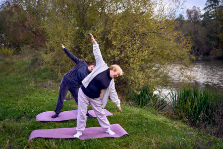 Ñ„  middle-aged woman teaches her old mother somatic exercises and yoga to maintain health by the...