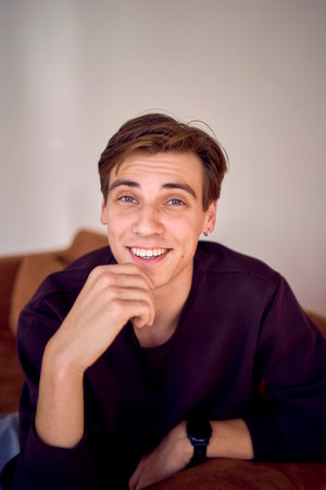 a  portrait of an attractive young 20 year old man with dark hair and blue eyes, studio photo shoot