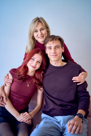 middle-aged mother hugs an adult son and a teenage daughterの写真素材